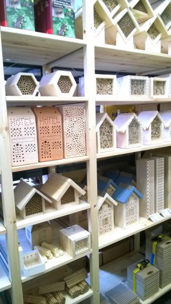 Mehrere professionell gebaute Insektennisthilfen stehen in einem Regal